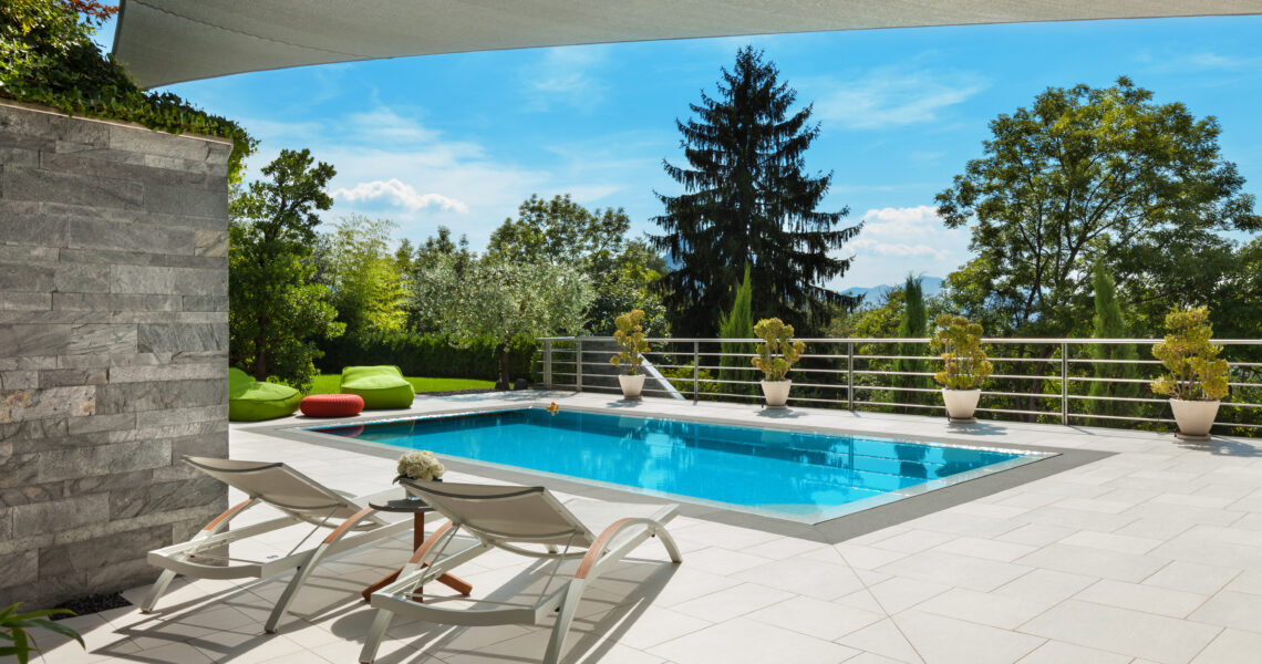 belle maison, vue sur la piscine depuis la véranda, journée d'été